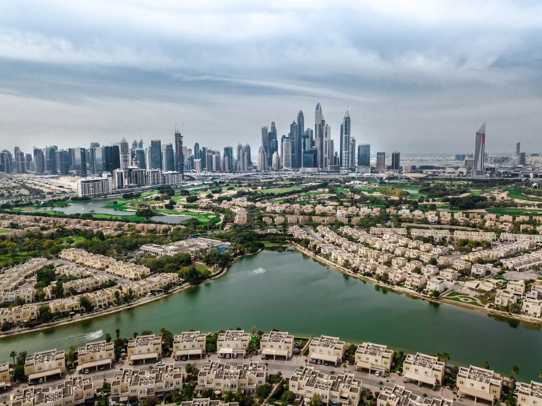 A golf course running through a residential community, with towers beyond