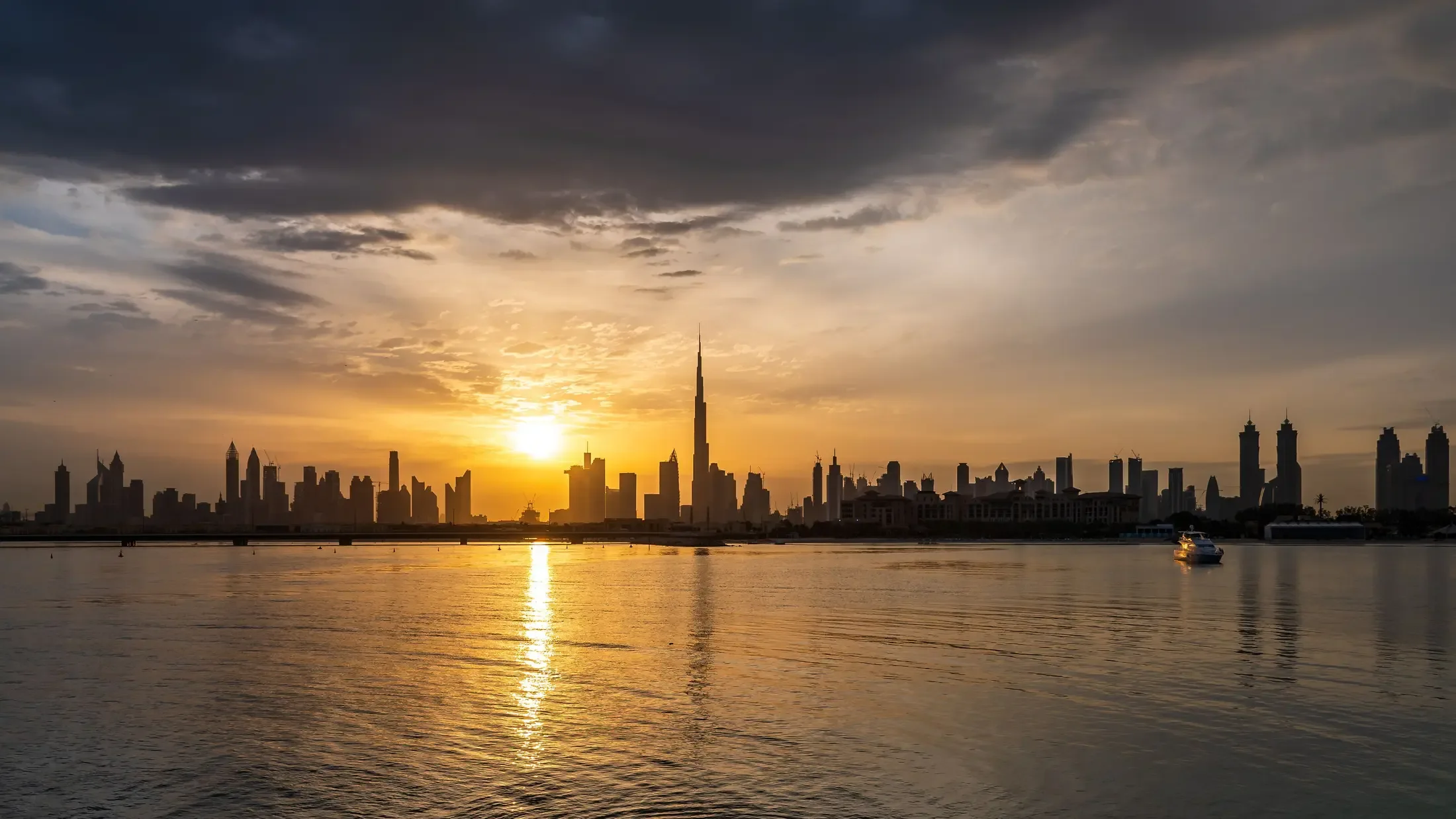 The Dubai skyline at sunset, seen across the water